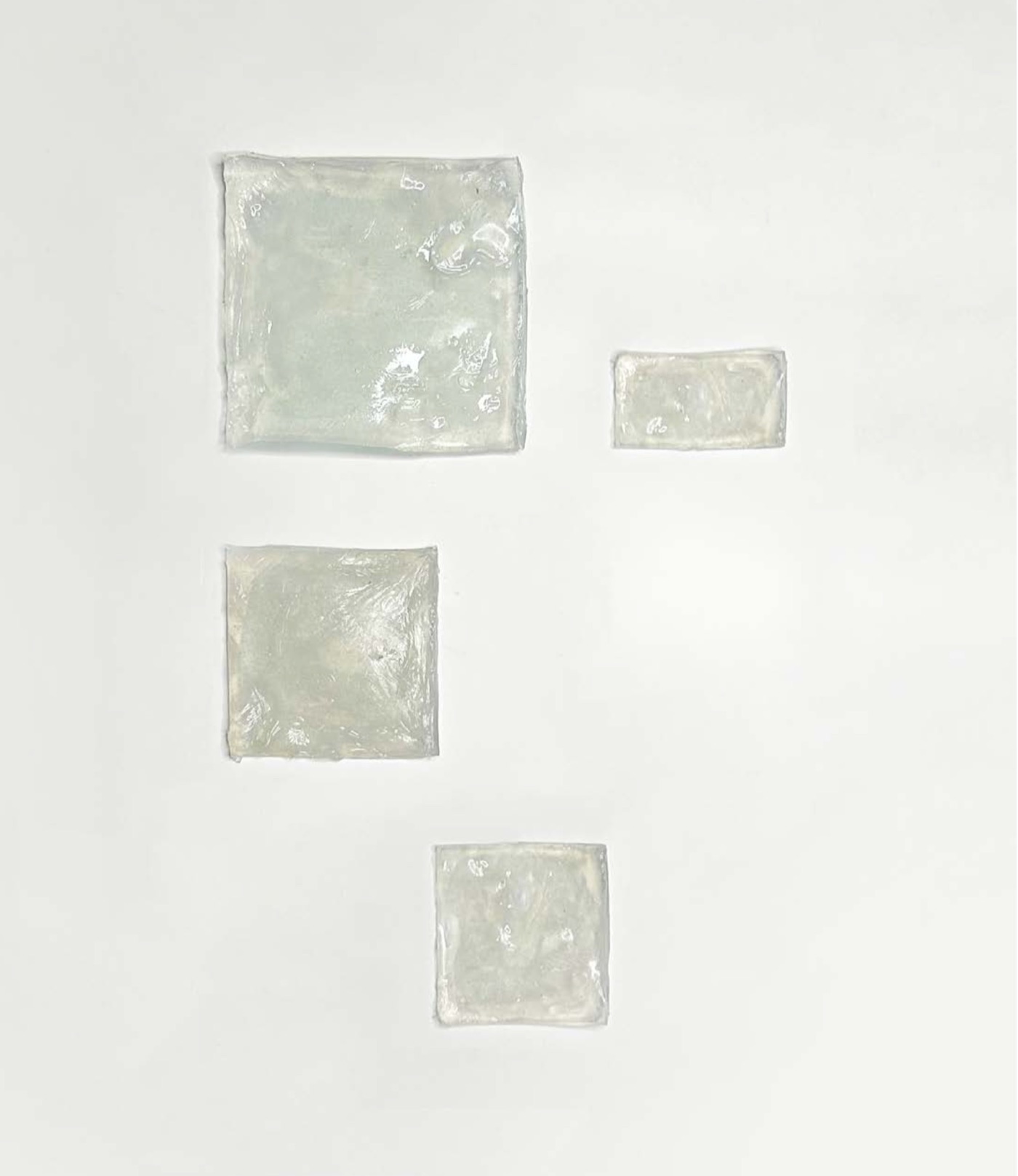 Carrés de matière translucide posés sur fond blanc