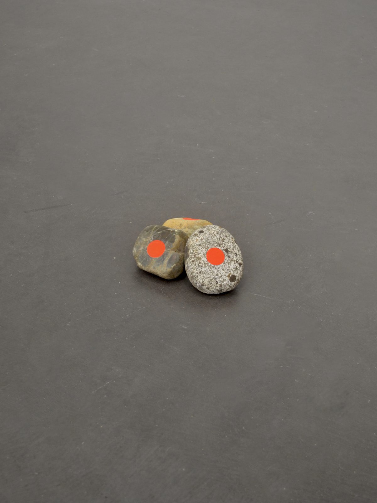 Trois cailloux marqués d’un point orange